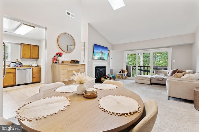 tiled dining area with a skylight and high vaulted ceiling