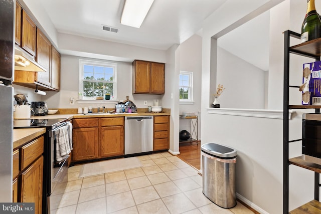 kitchen featuring sink, light tile patterned floors, and stainless steel appliances