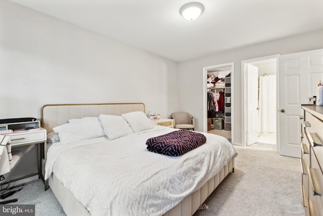 carpeted bedroom with connected bathroom, a spacious closet, and a closet