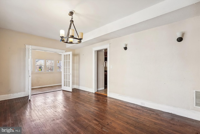 interior space with dark hardwood / wood-style floors, french doors, and a chandelier