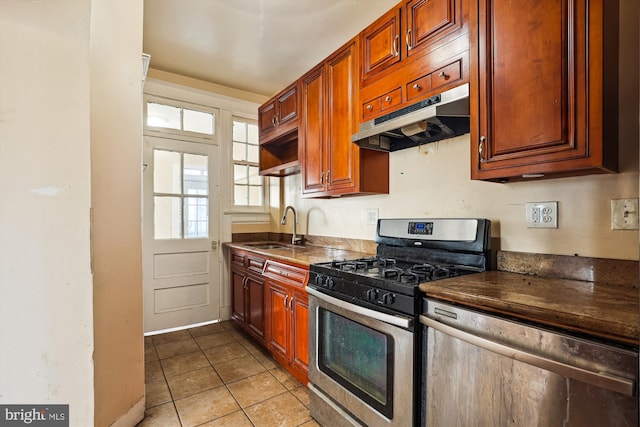 kitchen with sink, light tile patterned floors, and stainless steel gas range