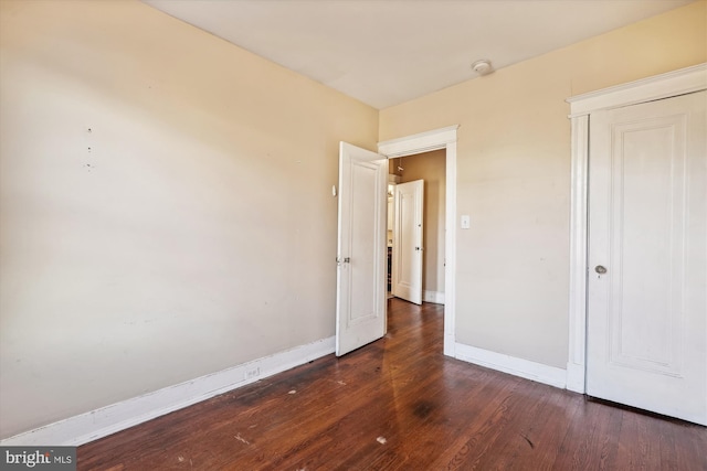 unfurnished bedroom with dark wood-type flooring