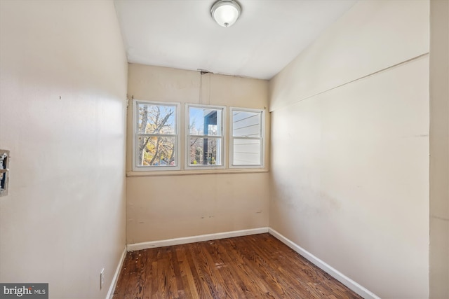 unfurnished room with dark wood-type flooring