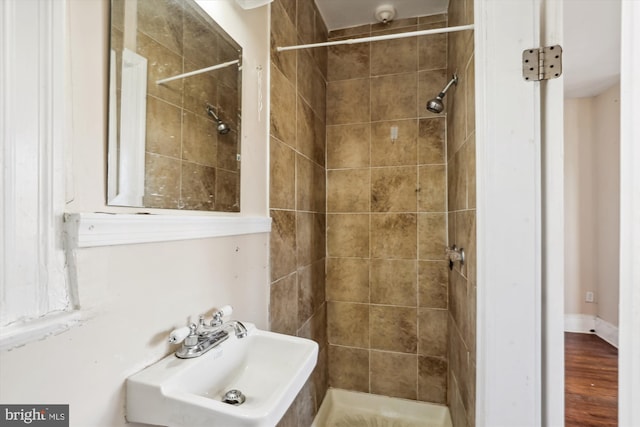 bathroom with sink, wood-type flooring, and tiled shower