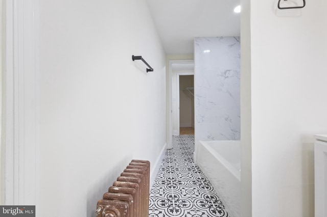 hall featuring radiator and light tile patterned flooring