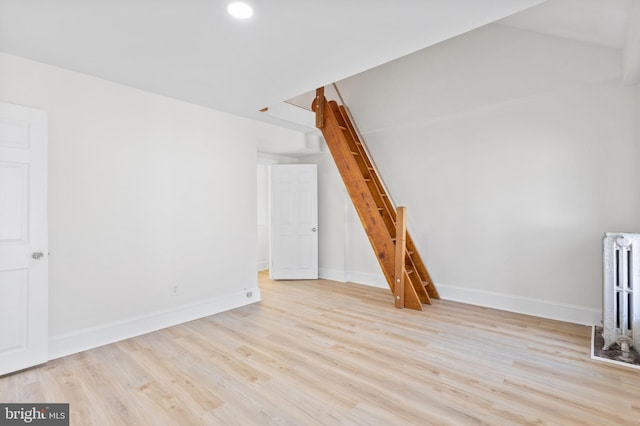 bonus room featuring radiator heating unit and light hardwood / wood-style flooring