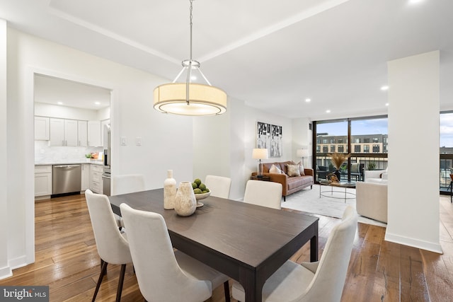 dining space featuring floor to ceiling windows and hardwood / wood-style floors