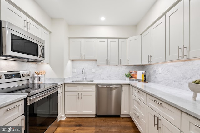 kitchen featuring backsplash, stainless steel appliances, sink, white cabinets, and dark hardwood / wood-style floors