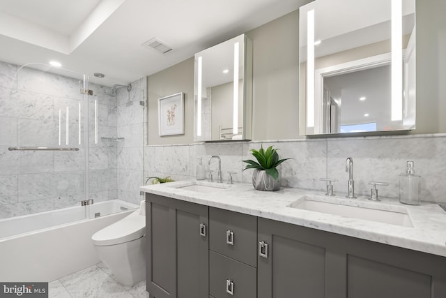 full bathroom featuring tiled shower / bath combo, toilet, backsplash, and vanity