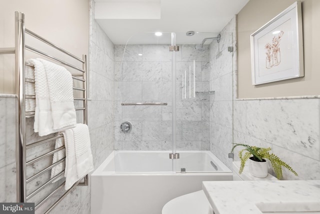 full bathroom with toilet, combined bath / shower with glass door, tile walls, and vanity