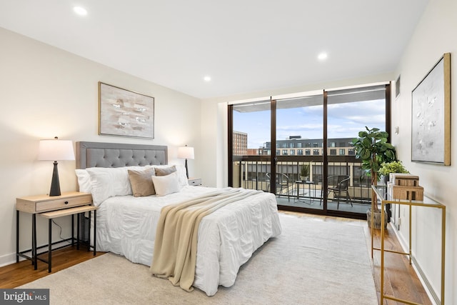 bedroom with access to outside and hardwood / wood-style flooring