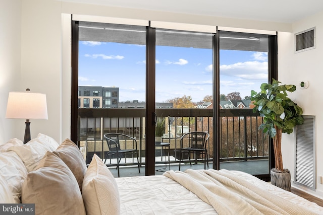 bedroom featuring access to exterior and hardwood / wood-style floors