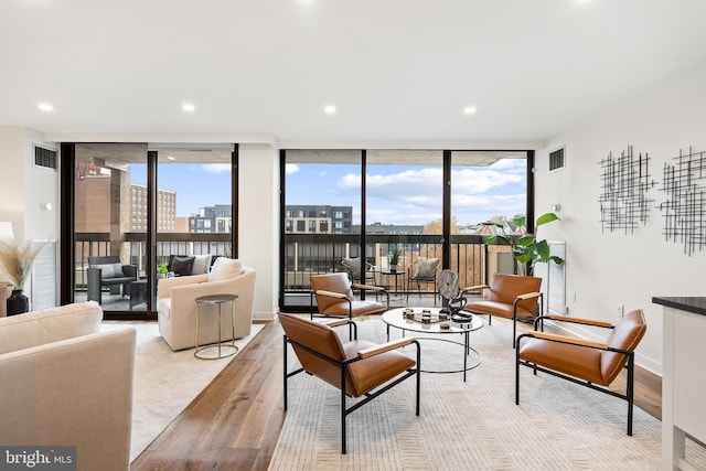 living room featuring floor to ceiling windows and light hardwood / wood-style floors