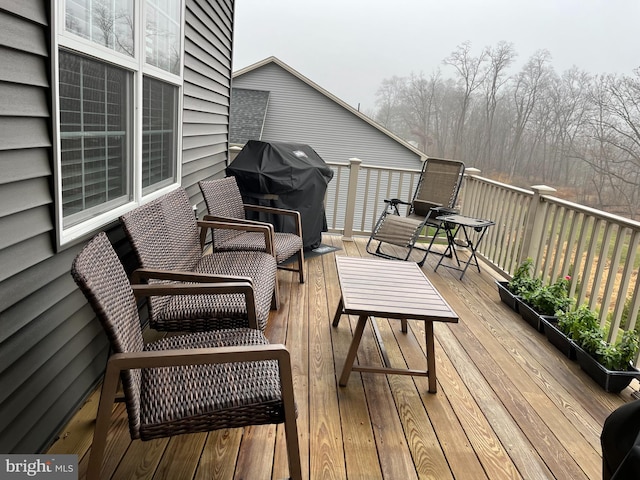 wooden terrace with a grill and an outdoor hangout area