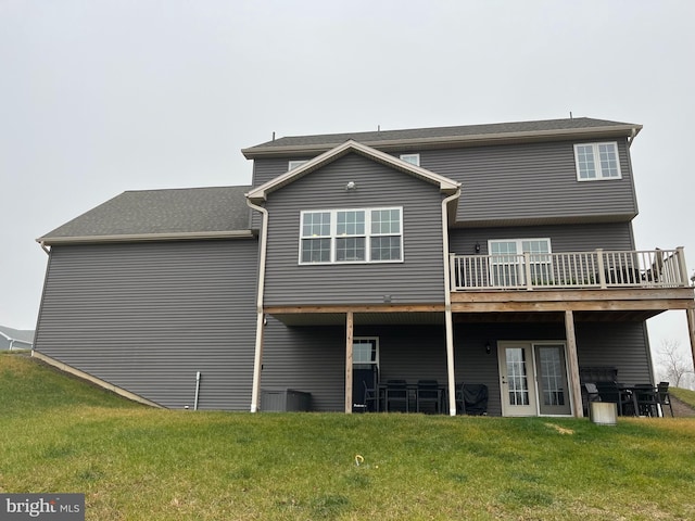 back of property with a deck and a lawn