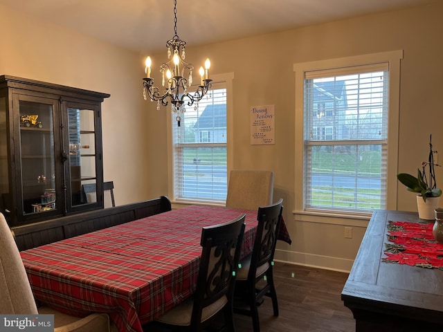 dining space with a notable chandelier and dark hardwood / wood-style floors