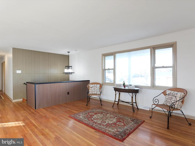 sitting room featuring wood-type flooring and a notable chandelier