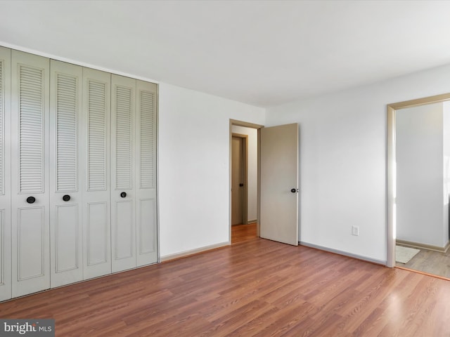 unfurnished bedroom with a closet and wood-type flooring