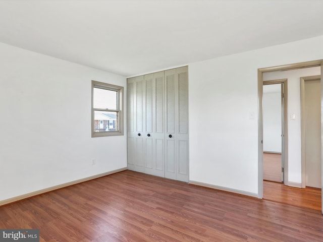 unfurnished bedroom featuring hardwood / wood-style floors and a closet