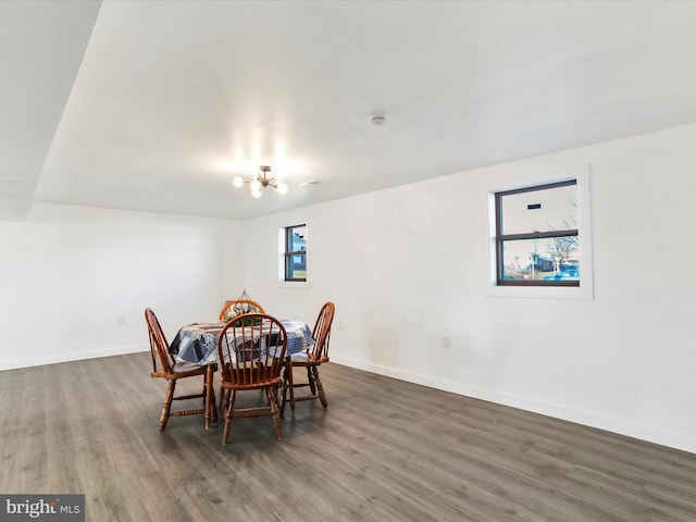 dining area featuring an inviting chandelier, plenty of natural light, and dark wood-type flooring