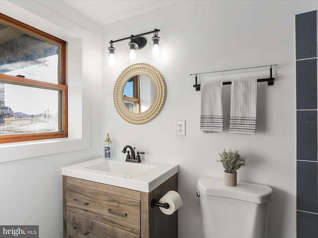 bathroom with plenty of natural light, vanity, and toilet