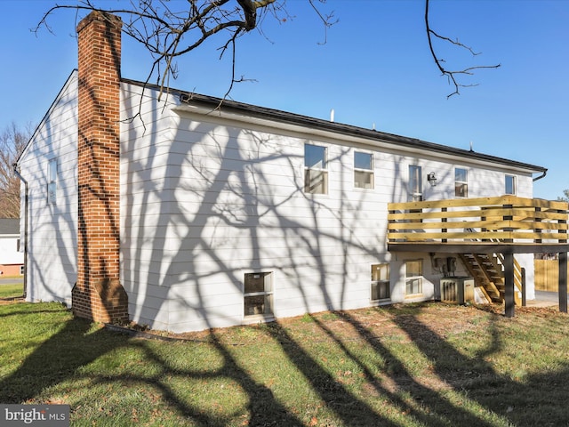 back of property with a deck and a lawn