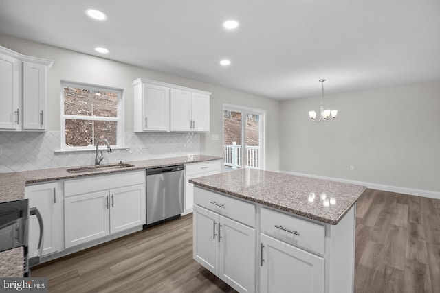 kitchen featuring dishwasher, white cabinets, hardwood / wood-style floors, and sink