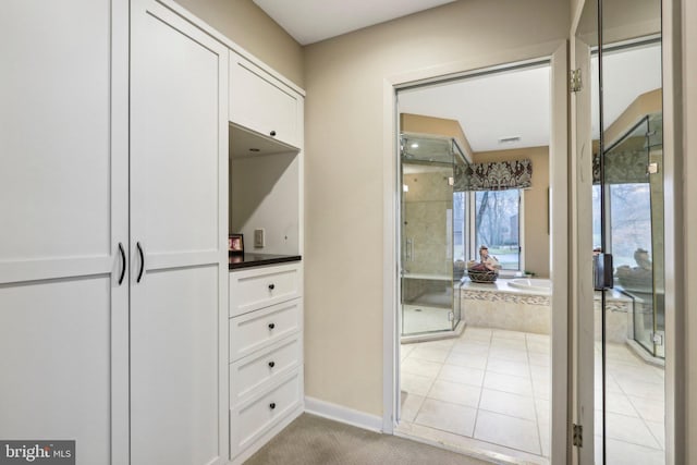 walk in closet featuring light tile patterned flooring