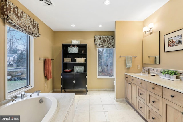 bathroom featuring tile patterned floors, tiled bath, and vanity