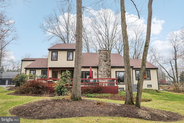 view of front facade featuring a wooden deck and a front yard