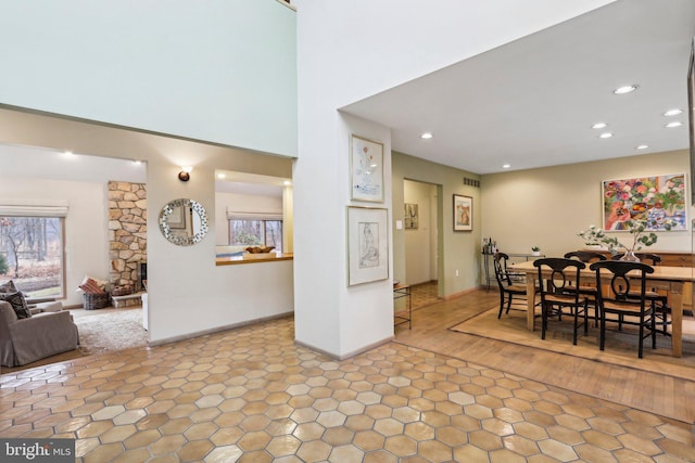 dining space featuring hardwood / wood-style flooring, a stone fireplace, and a wealth of natural light