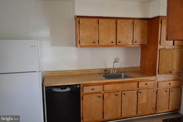 kitchen featuring white refrigerator, sink, and black dishwasher