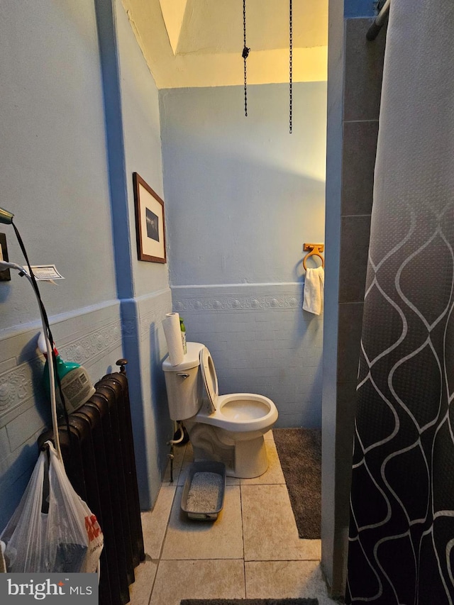 bathroom featuring tile patterned floors, tile walls, and toilet