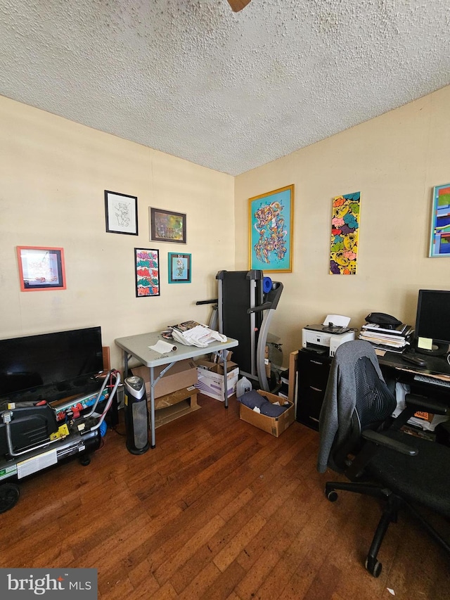 home office with a textured ceiling and dark hardwood / wood-style floors