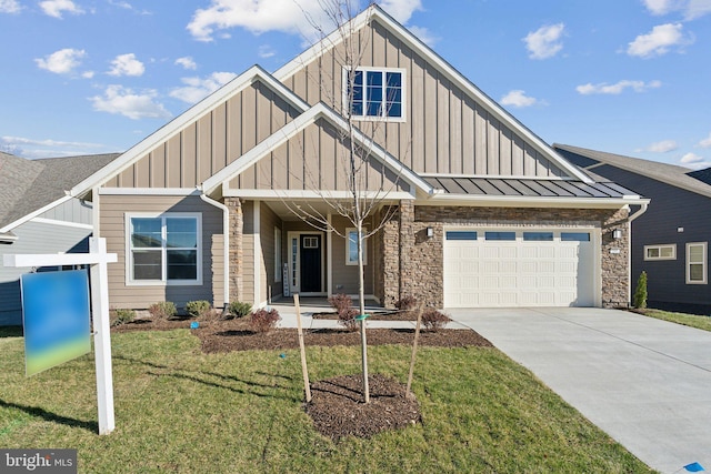 view of front of property with covered porch, a garage, and a front lawn