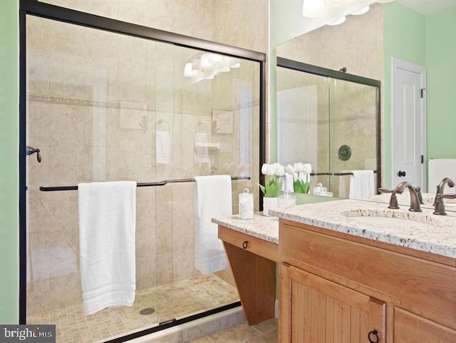 bathroom featuring tile patterned flooring, walk in shower, and vanity