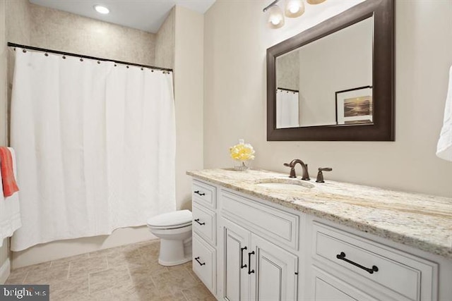 bathroom with toilet, vanity, and tile patterned flooring