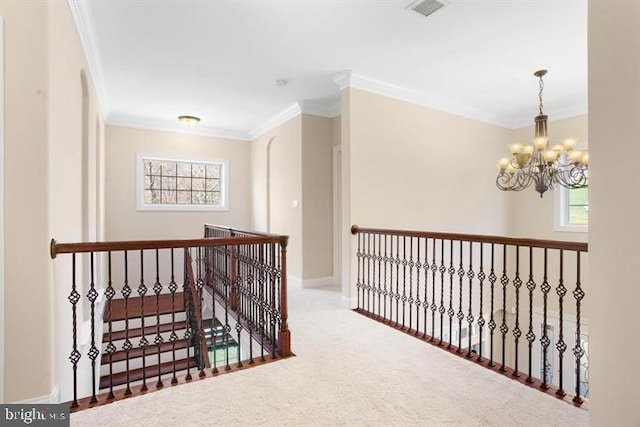 corridor featuring carpet flooring, ornamental molding, and a notable chandelier