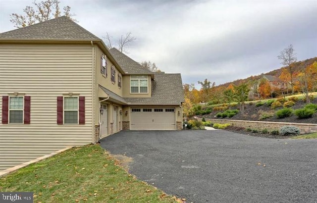 view of property exterior with a mountain view and a garage