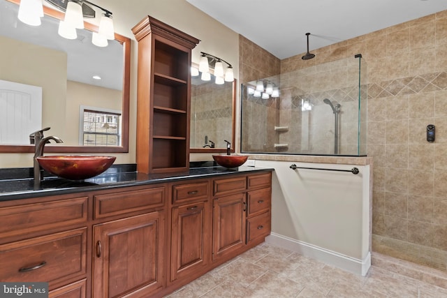 bathroom with tile patterned floors, tiled shower, and vanity