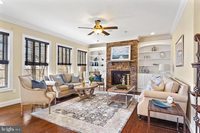 living room with ornamental molding, dark wood-type flooring, a stone fireplace, and a healthy amount of sunlight