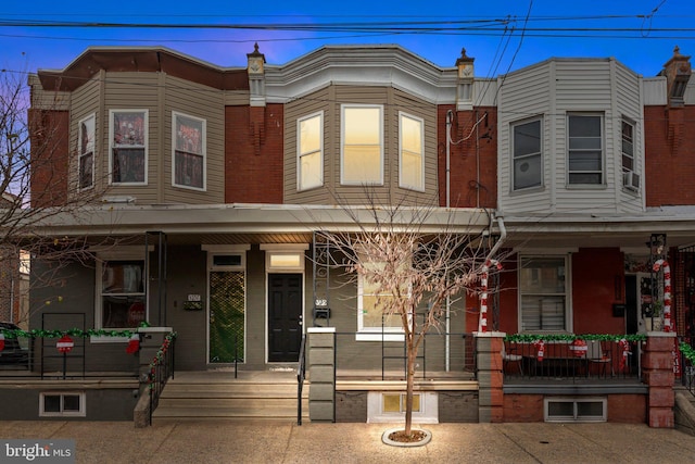 townhome / multi-family property featuring cooling unit and a porch