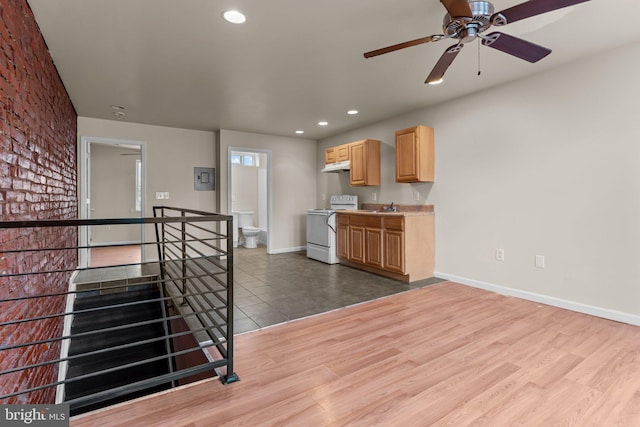 kitchen featuring hardwood / wood-style floors, light brown cabinets, sink, ceiling fan, and white range oven