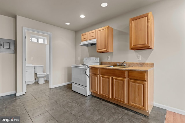 kitchen featuring range, dark tile patterned floors, and sink