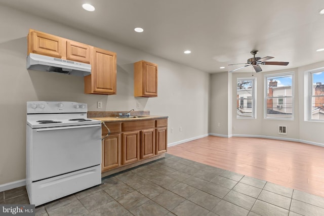 kitchen with light brown cabinets, sink, light hardwood / wood-style flooring, ceiling fan, and white range with electric stovetop