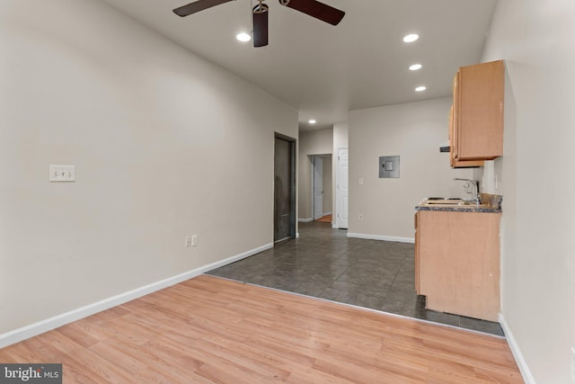 kitchen with ceiling fan, sink, light brown cabinets, electric panel, and dark hardwood / wood-style floors