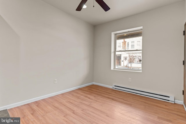 empty room with baseboard heating, ceiling fan, and light wood-type flooring