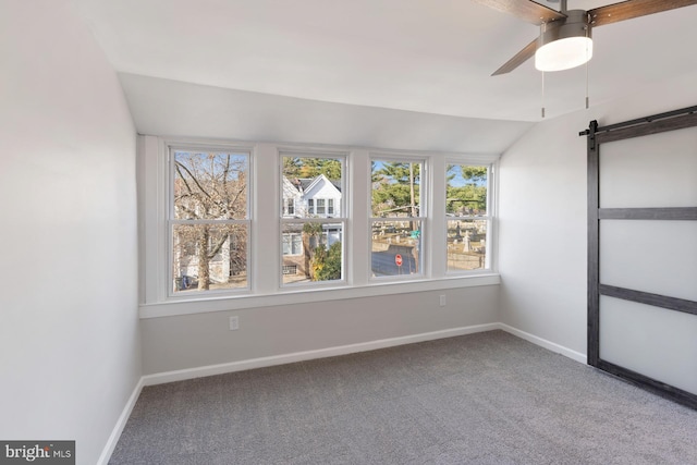 spare room with carpet, a barn door, ceiling fan, and lofted ceiling