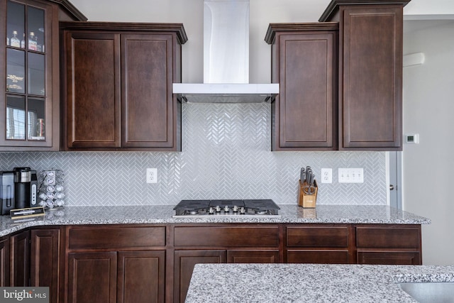 kitchen featuring tasteful backsplash, dark brown cabinets, and wall chimney exhaust hood