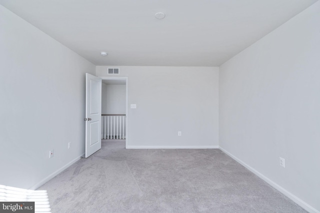 spare room featuring light colored carpet